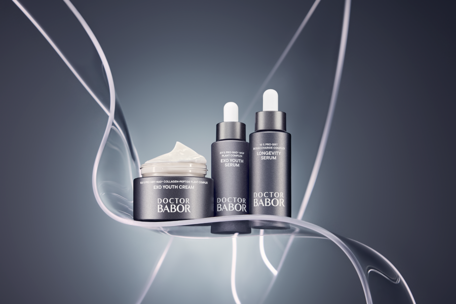 Drei elegante Doctor BABOR PRO Produkte – Serum, Peeling und Creme – stilvoll auf grauen Boxen arrangiert.